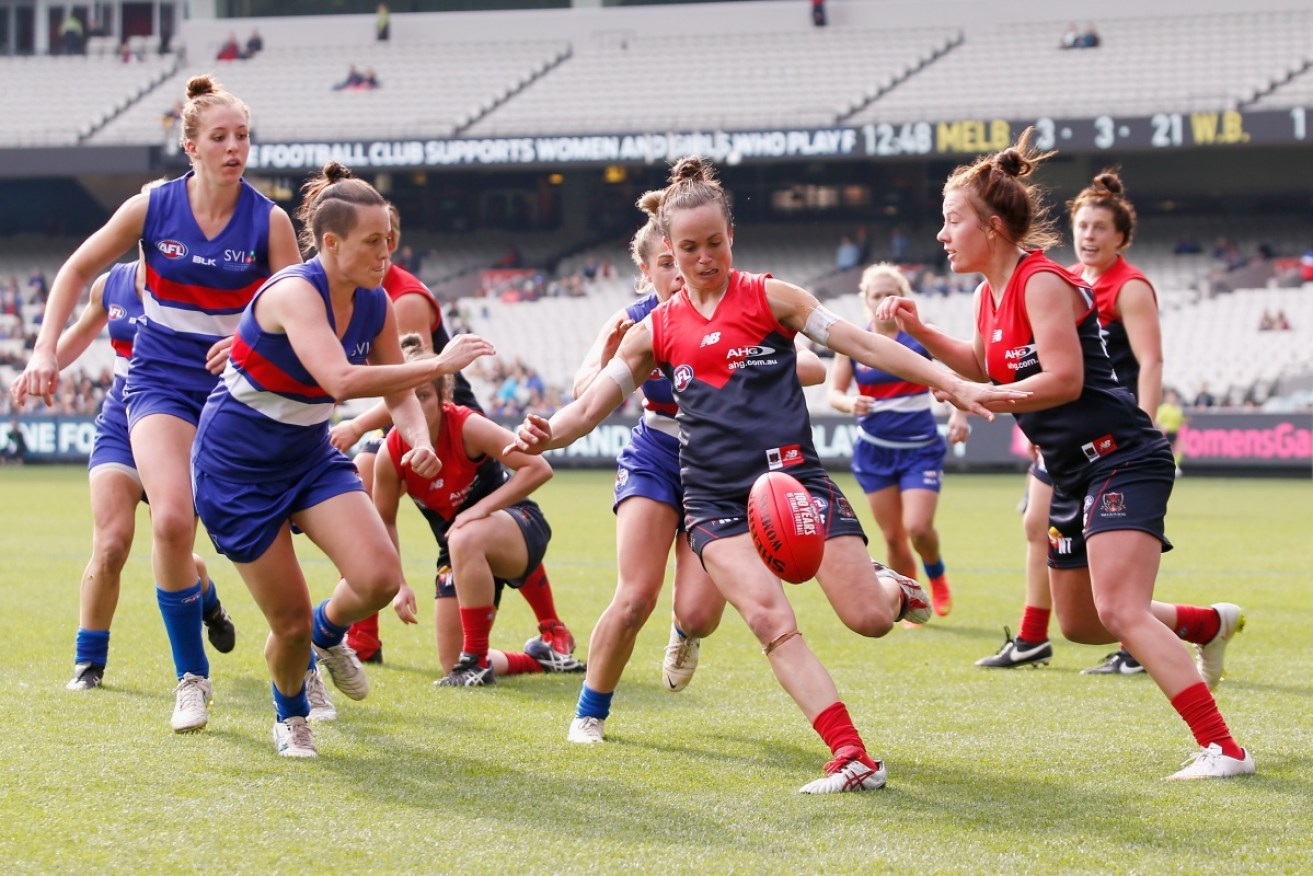 Daisy Pearce kicks downfield during a 2015 AFLW exhibition match.