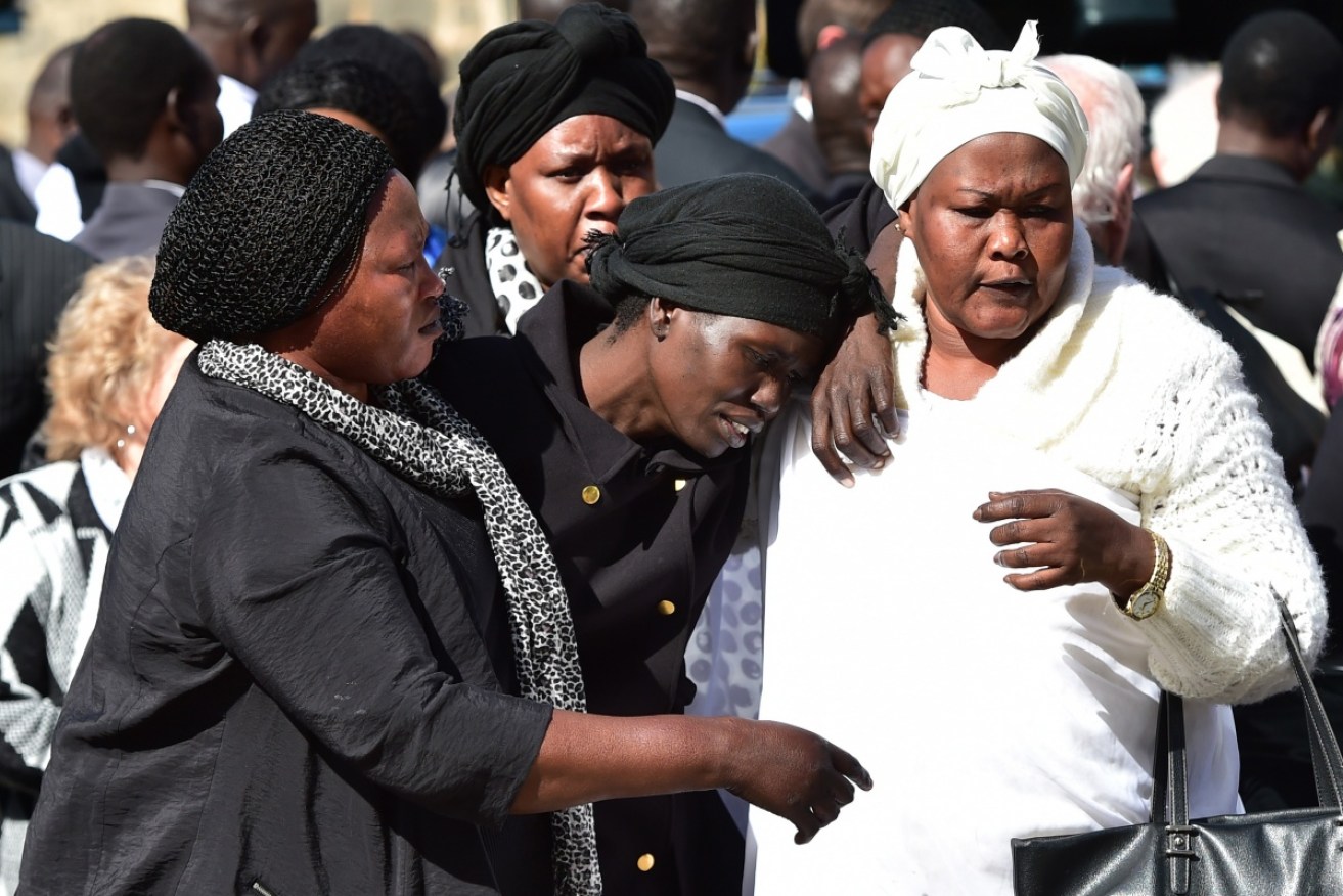 Guode, 37, attends the funeral of her three children in 2015. 