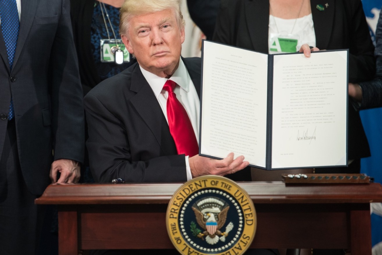 Donald Trump displays the Executive Order on immigration.