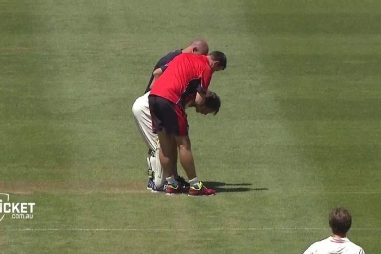 Victorian wicketkeeper Sam Harper is assisted after being struck by a bat.