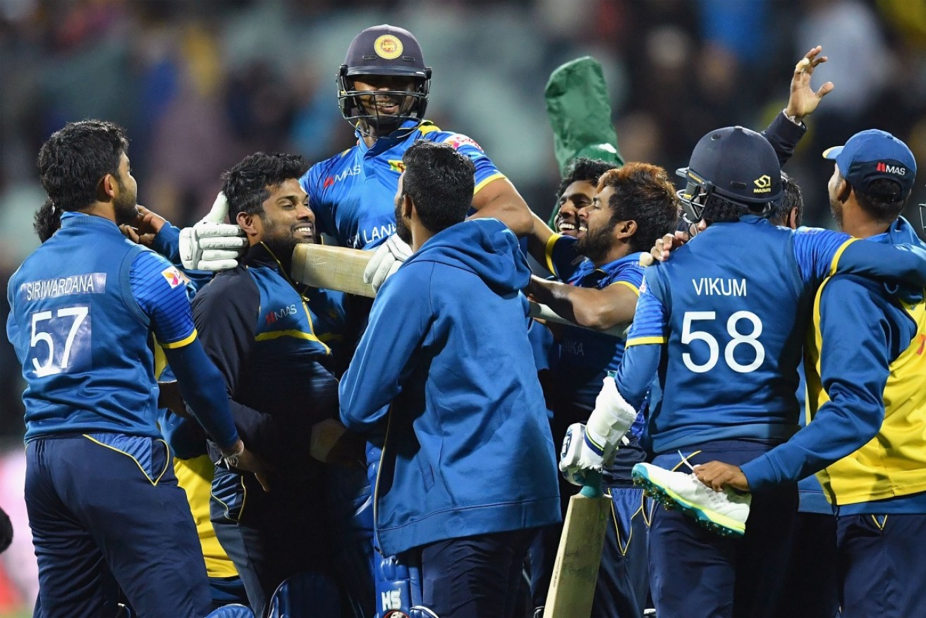 Asela Gunaratne celebrates with teammates after hitting the winning runs for Sri Lanka.