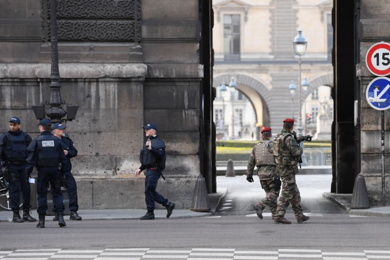 French police officers and soldiers patrol in front of the Louvre after a man reportedly attempted to carry out a terrorist attack