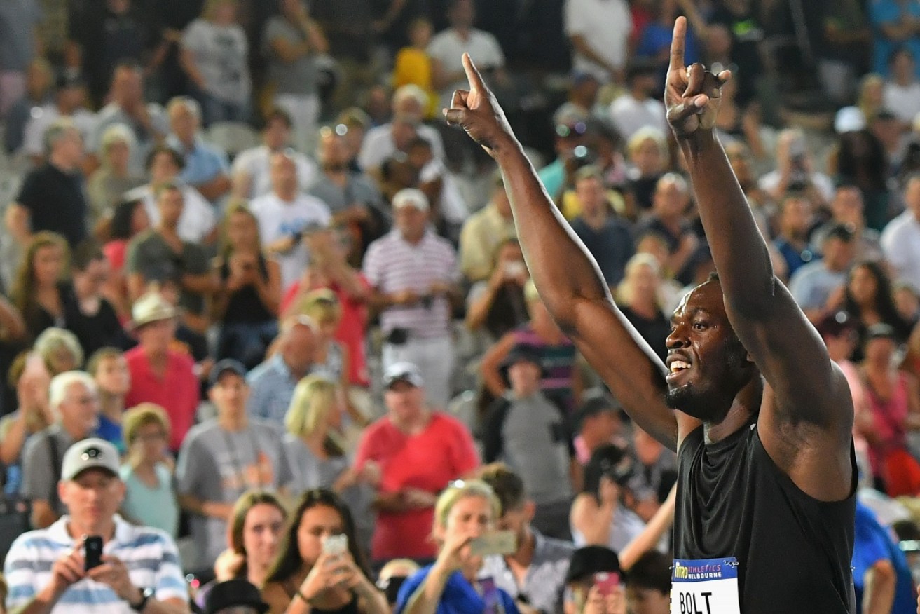 Usain Bolt waves to the crowd after competing in the relay.