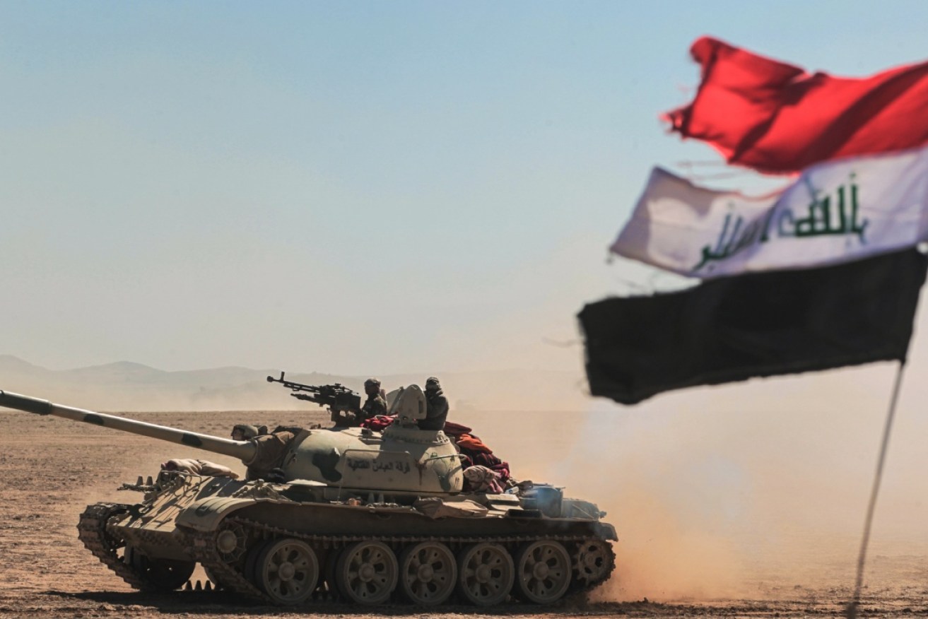 Tanks and armoured vehicles of the Iraqi armed forces advance towards a village south of Mosul.