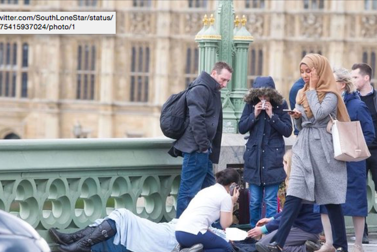 Freelance photographer Jamie Lorriman has defended the actions of a woman wearing a hijab walking past a victim of London's terror attacks says she looked "truly distraught". Photo: Twitter/James Lorriman 