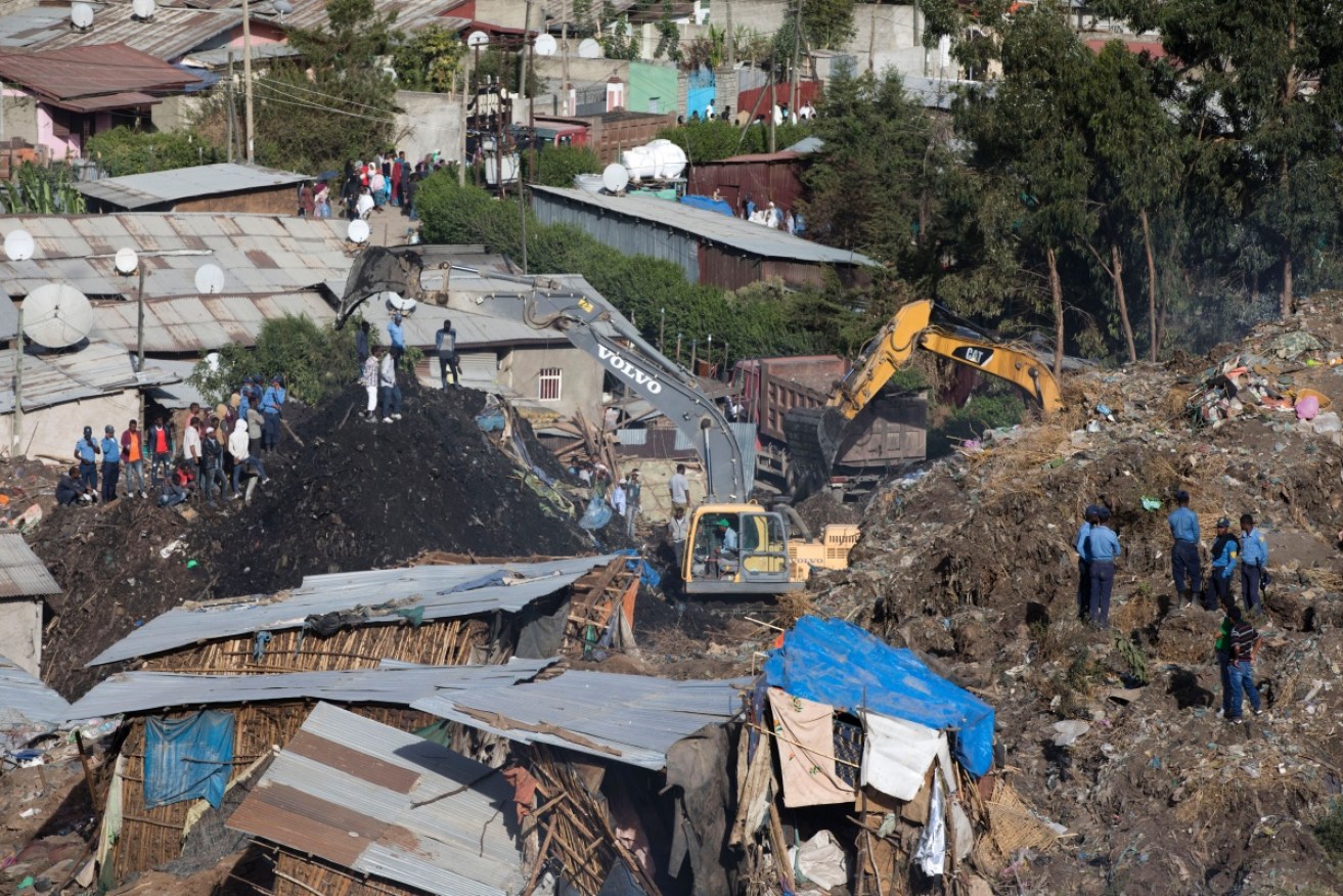 Rescuers work to find survivors among the rubbish dump landslide aftermath. 