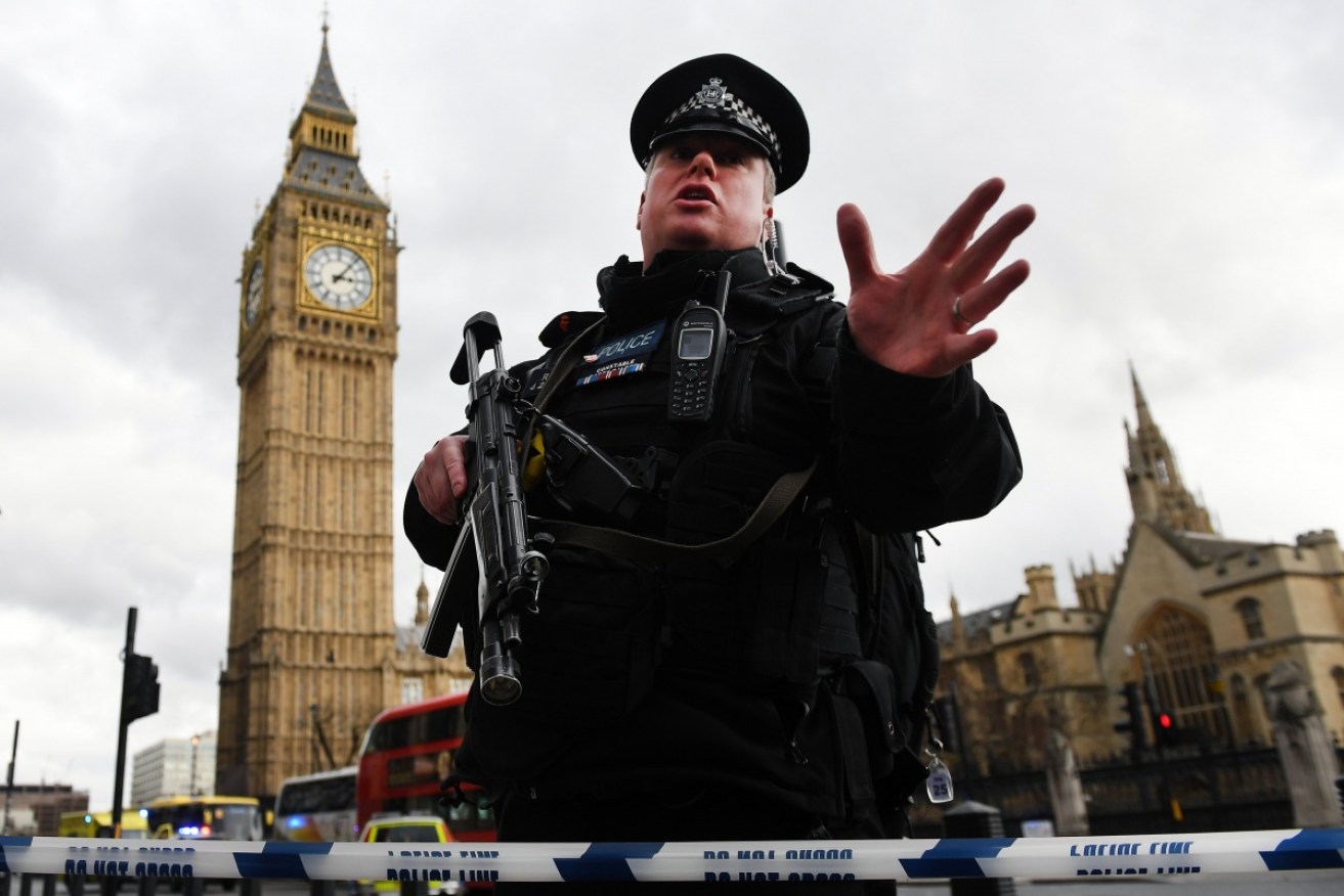 A police officer urges people away from the horrific scene near Westminster Palace.