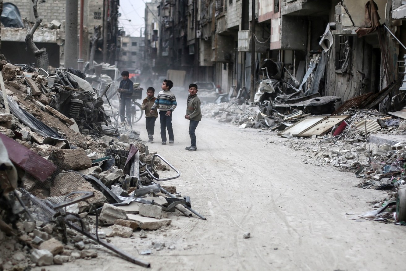 Children stand between the rubble, rebel-held Douma, Syria. 