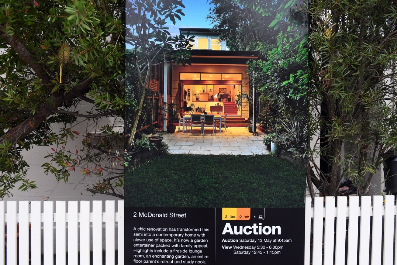 An auction sign is displayed in front of a house in Sydney. Photo: AAP
