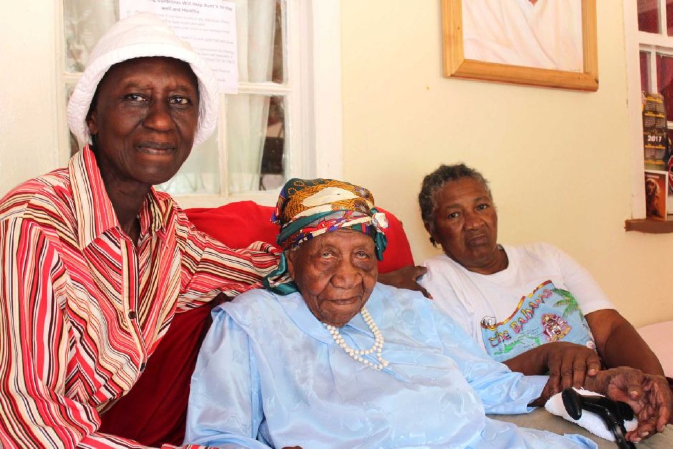 Violet Brown (C) sits with her two caregivers at her home in western Jamaica.