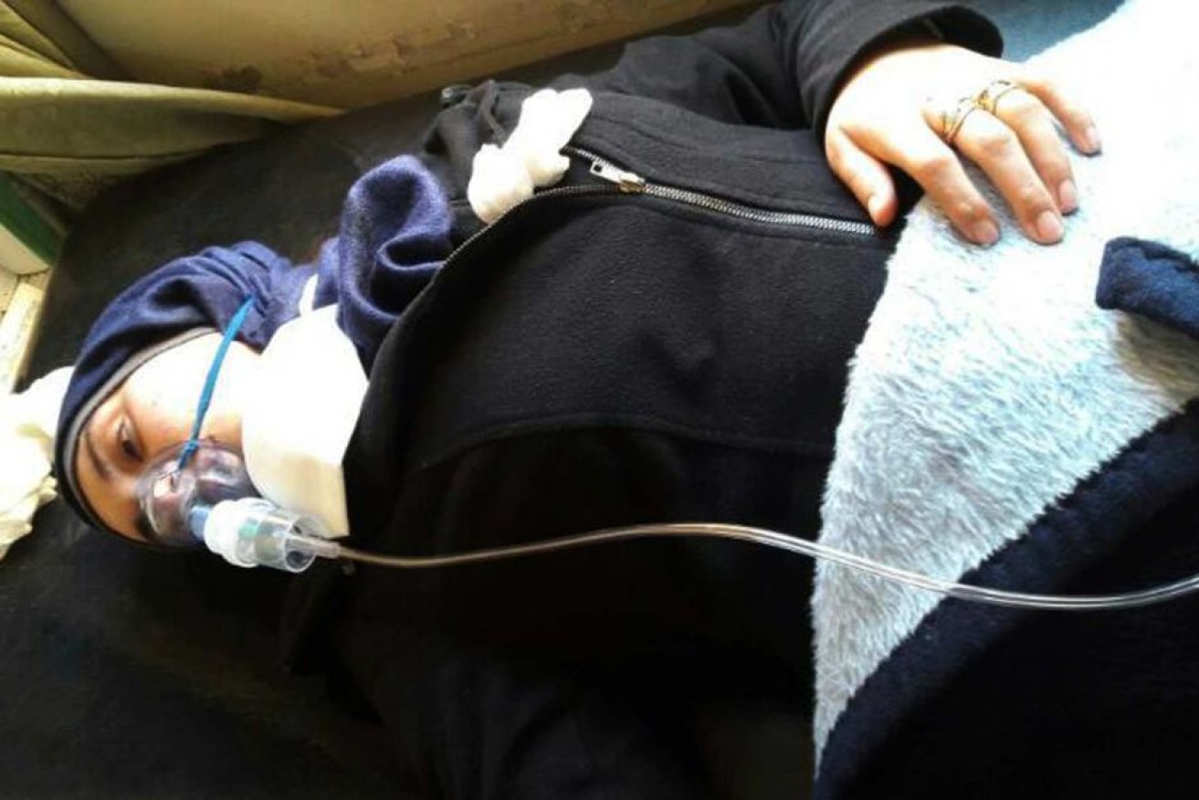 Aya Fadl lies on a bed with an oxygen mask to heal breathing difficulties following the attack in Khan Sheikhoun.