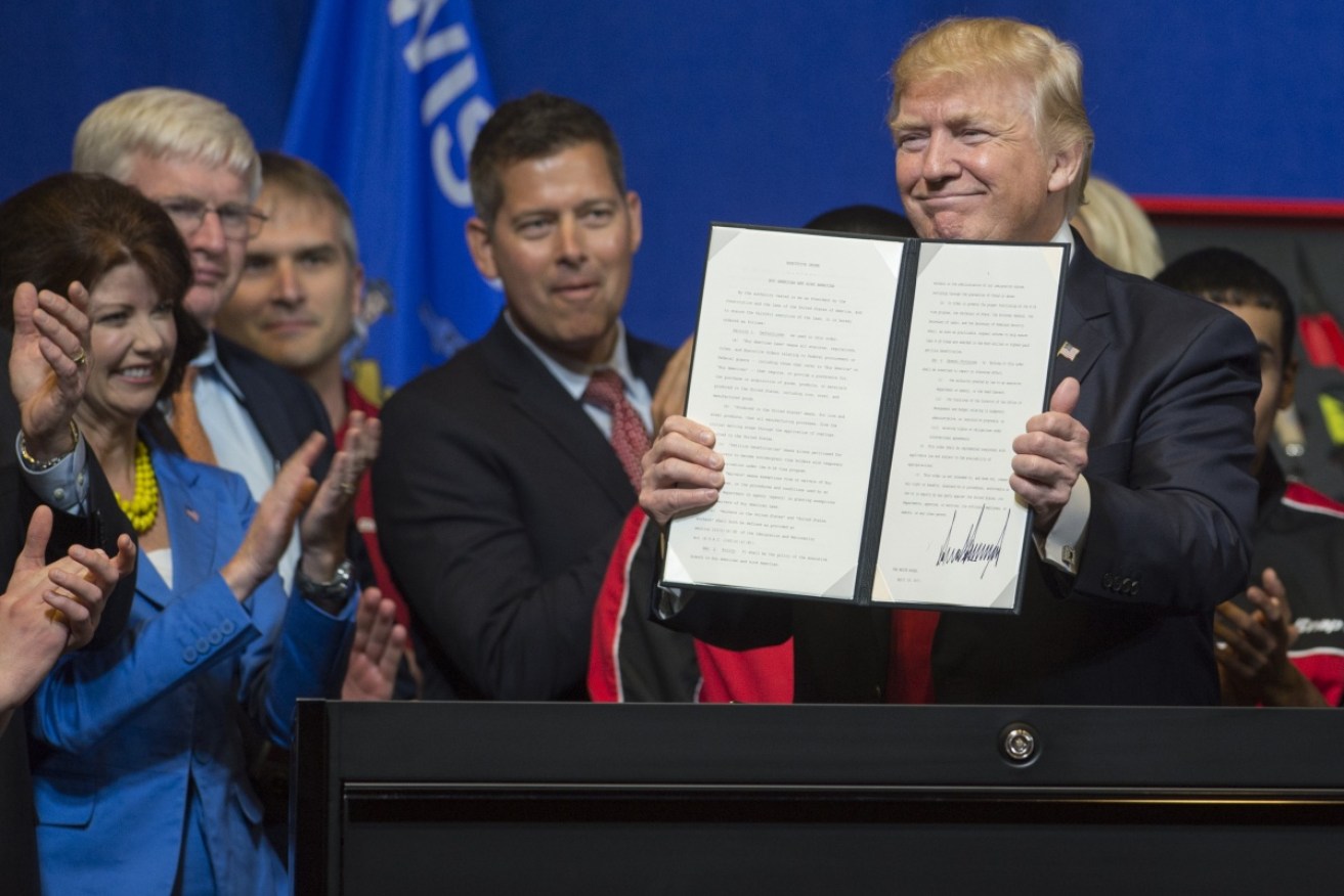 Trump with his Buy American, Hire American Executive Order. Photo: Getty