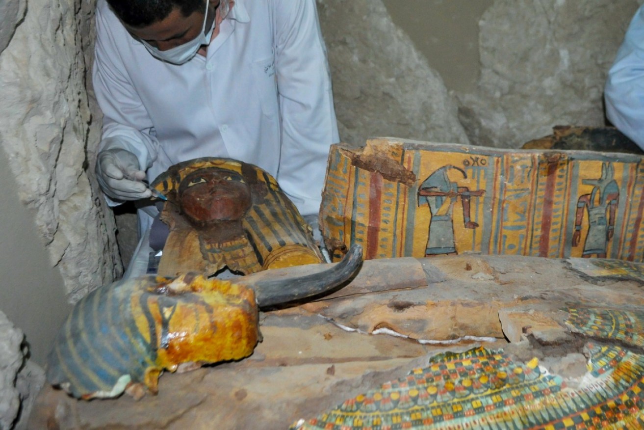 Egyptian archaeologists document the content of a recently discovered tomb.
