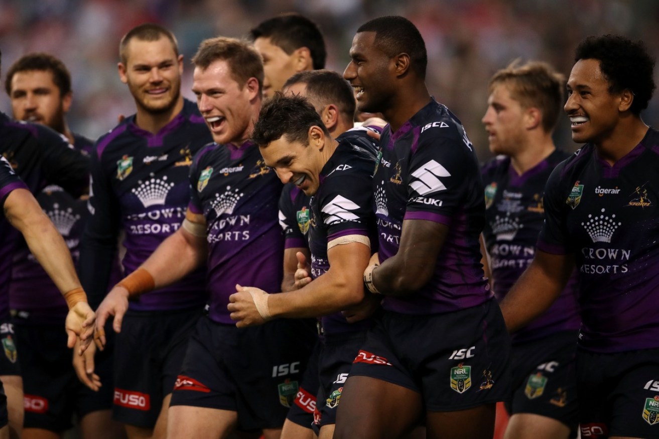 Billy Slater celebrates with his teammates after scoring a try against the Dragons.