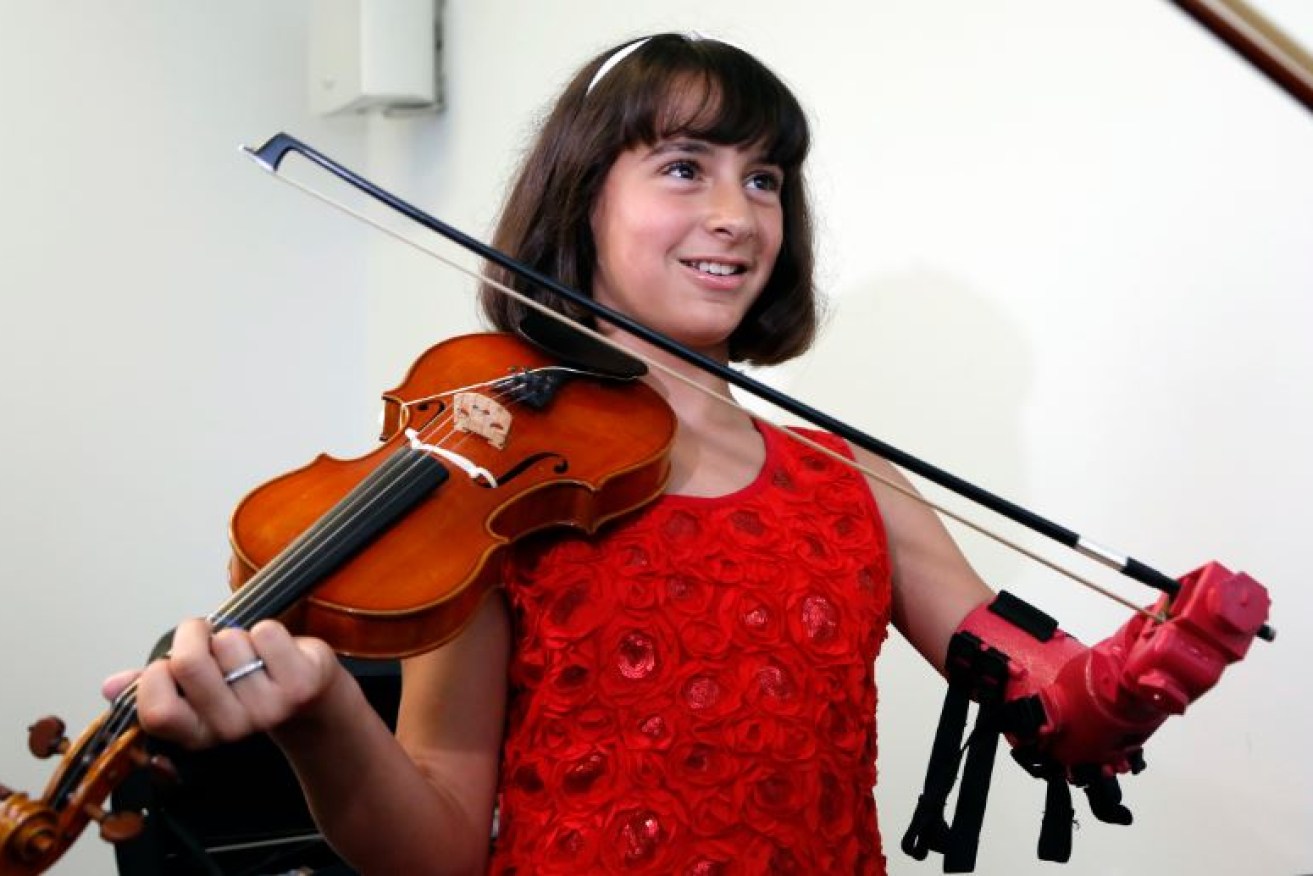 Isabella Cabrera beams with delight as she plays her violin for the first time with her new robotic arm.
