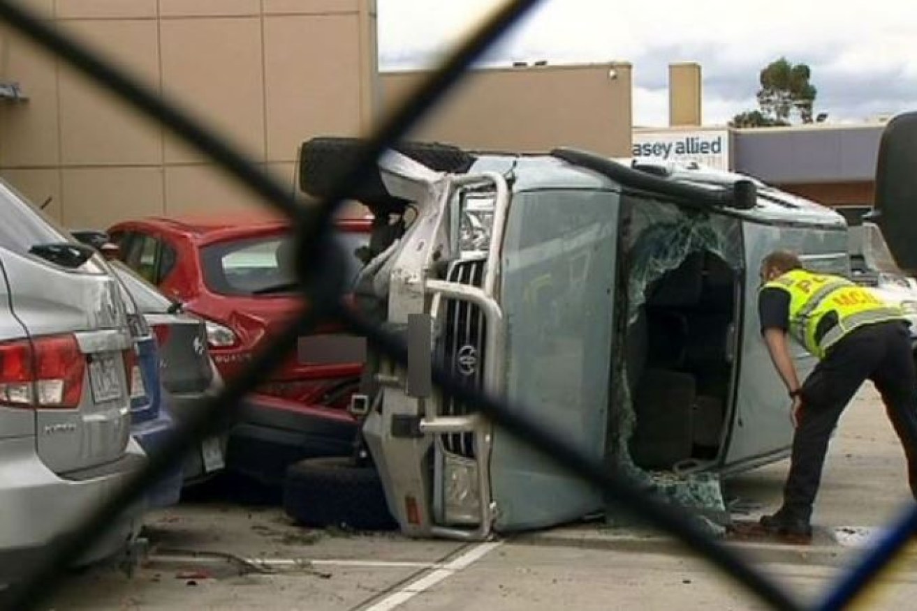 A police officer peers into the overturned Land Cruiser after Brax Kyle was killed in a Melbourne carpark on Friday.