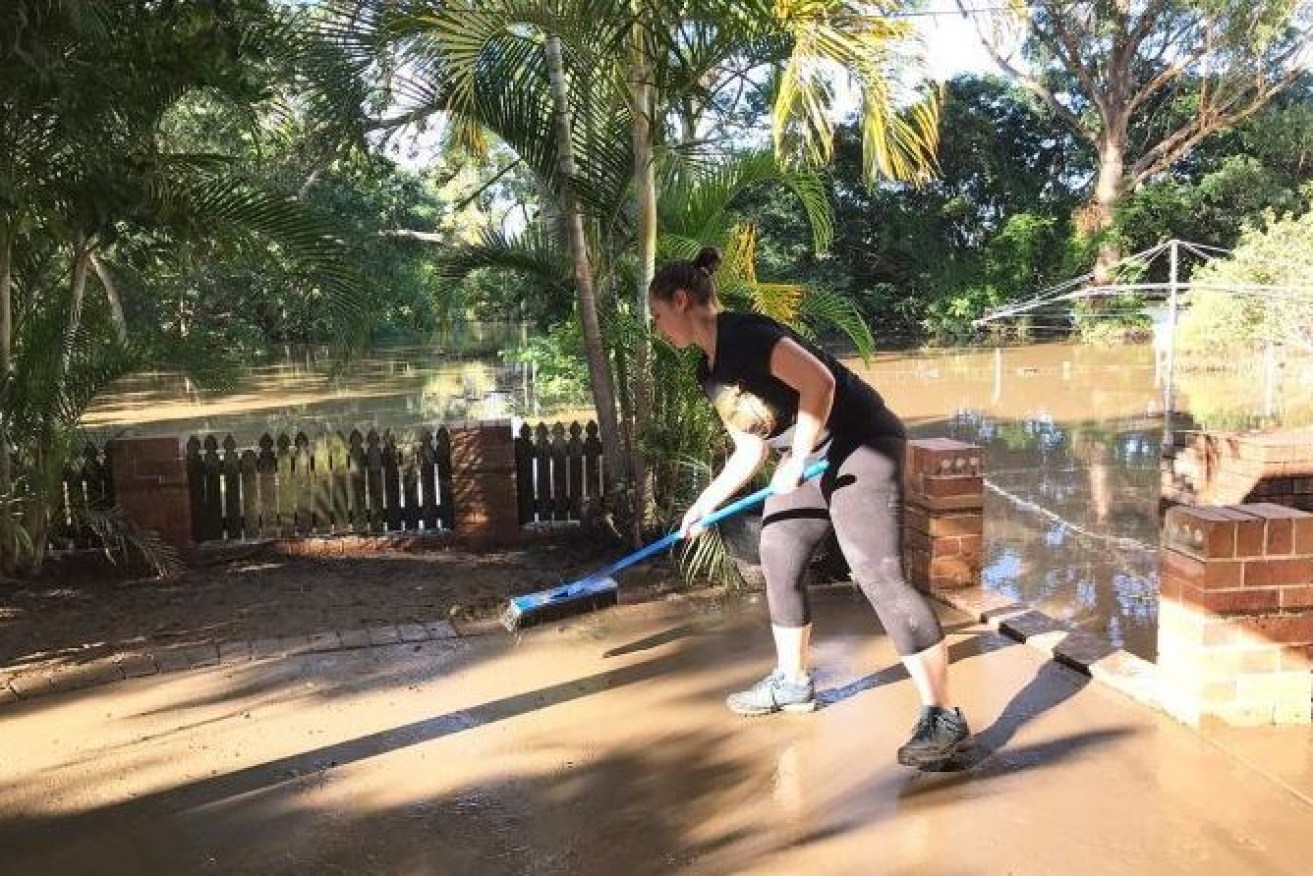 A Logan resident begins the long and arduous process of recovery as flood waters recede.