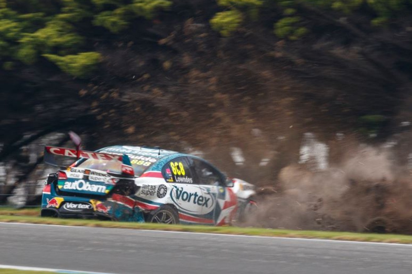 Craig Lowndes' battered Commodore slides to a halt in a cloud of dust at the Phillip Island Grand Prix Circuit.