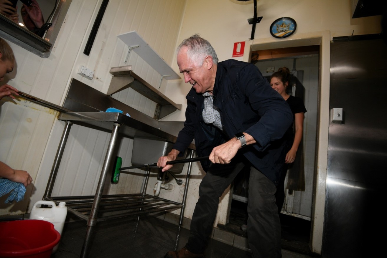 Malcolm Turnbull helps people in NSW clean up after the floods. 