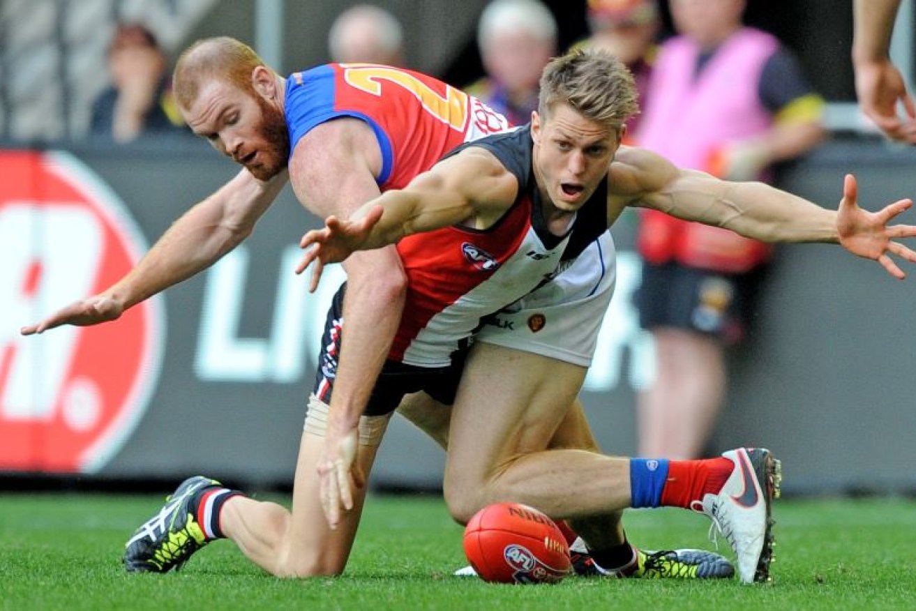 The Saints tenacious Sean Dempster on the receiving end of a hard tackle by Sean Dempster of the Saints is tackled by the Lions' Daniel Merrett late in the 2016 season.