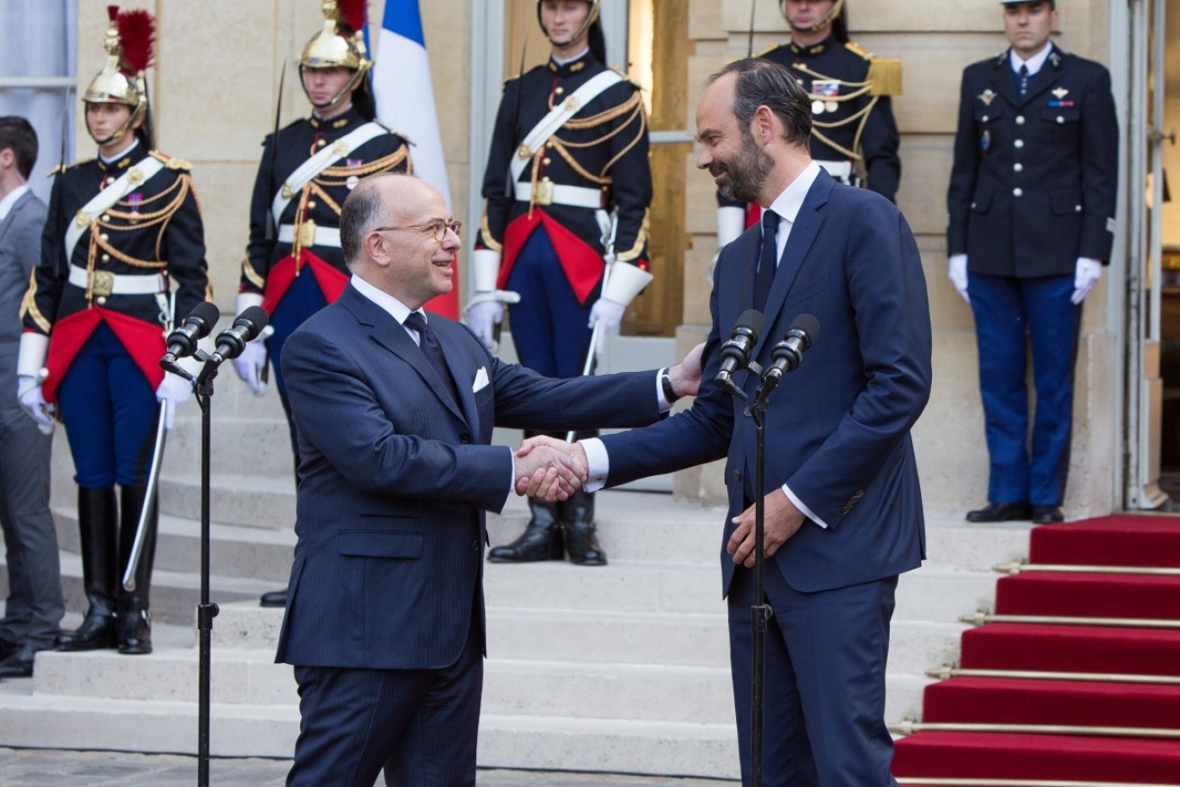 French outgoing Prime Minister Bernard Cazeneuve (left) and his successor Edouard Philippe shake hands.
