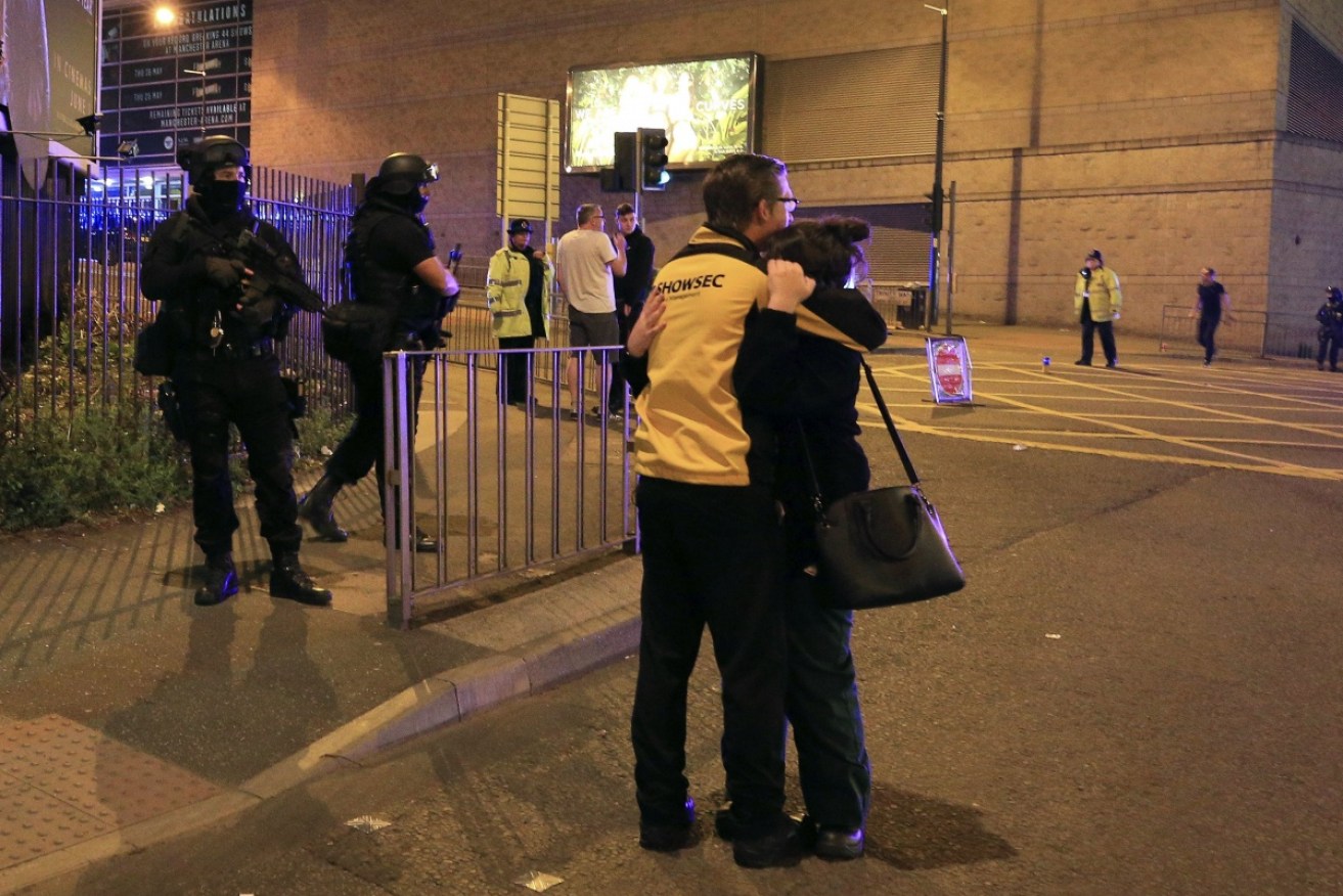 A man and a woman embrace outside of Manchester Arena after a terrorist suicide bombing.