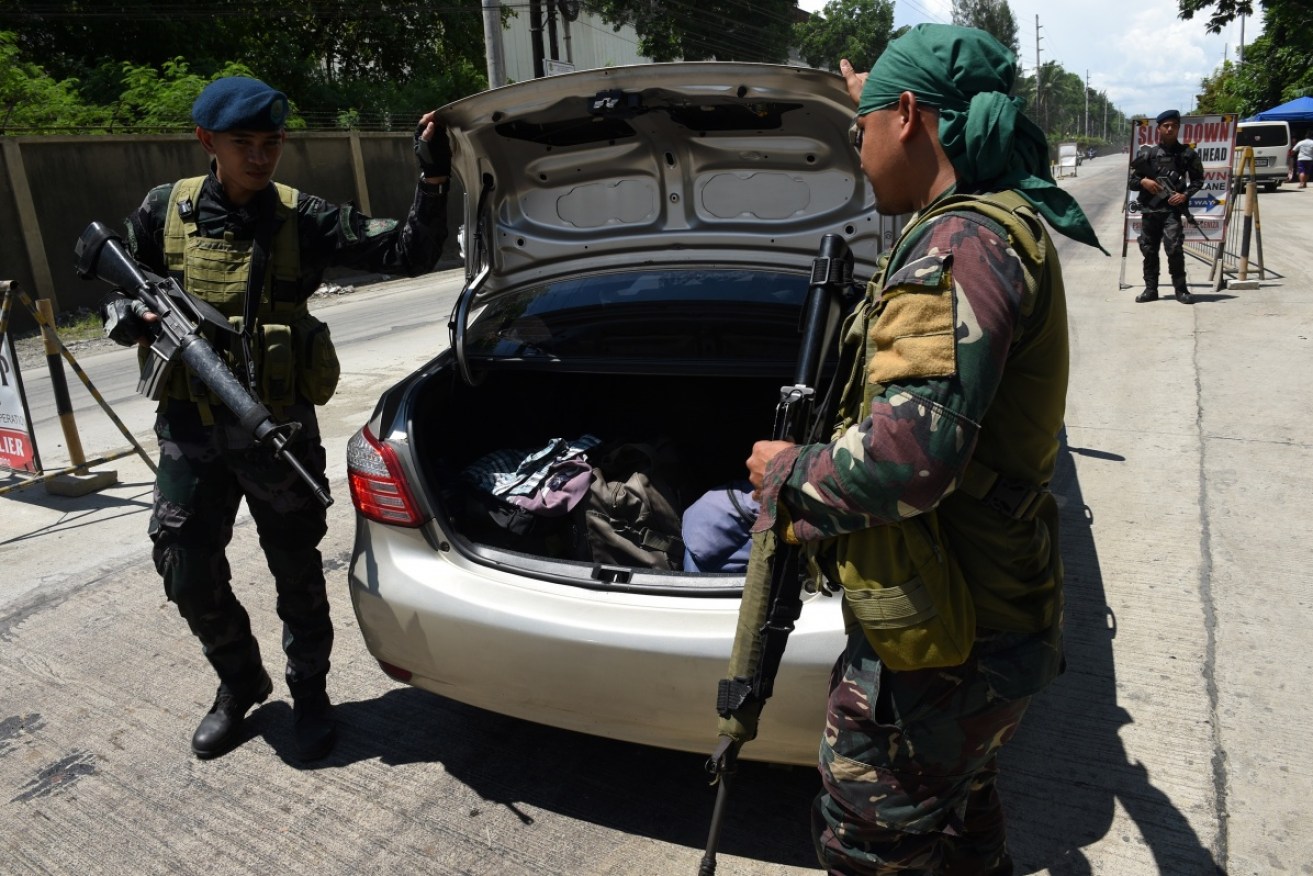 Security officers searching a car at a checkpoint on Tuesday in Iligan, on the southern Philippine island of Mindanao. The island is under military control because of a growing insurgent threat.