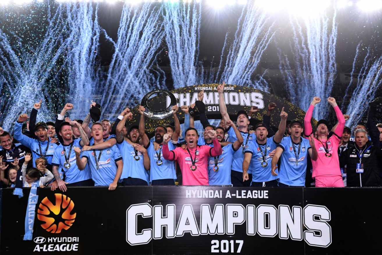 We are the champions! Sydney FC hold the trophy aloft.
