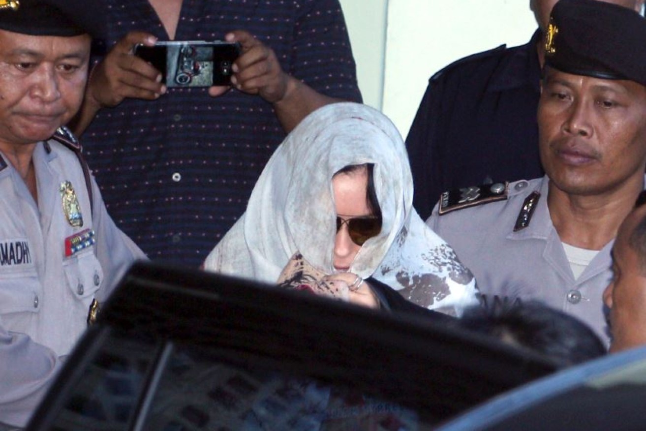 With her face hidden by sunglasses and a scarf, Schapelle Corby leaves the parole office.