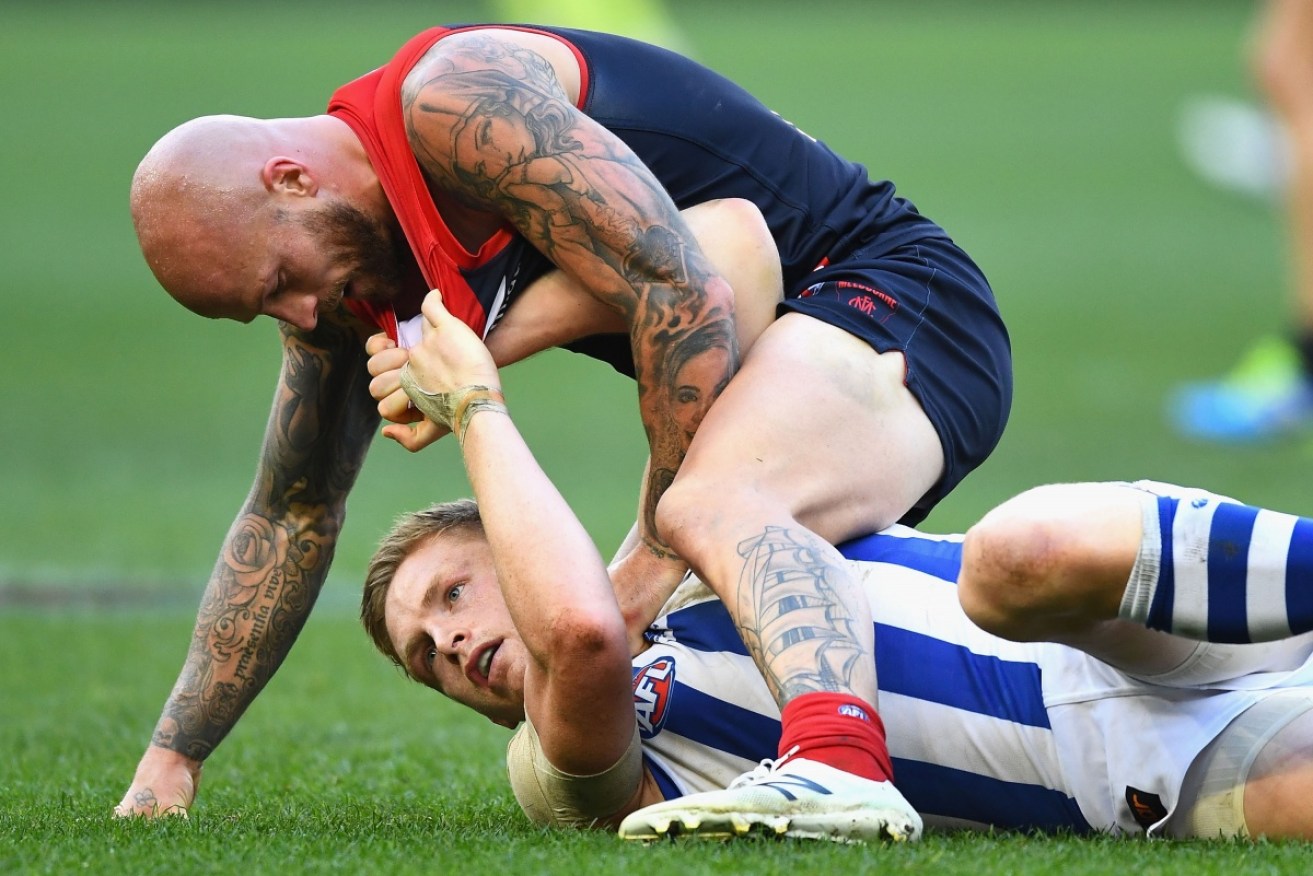 Nathan Jones of the Demons wrestles with North's Jack Ziebell.