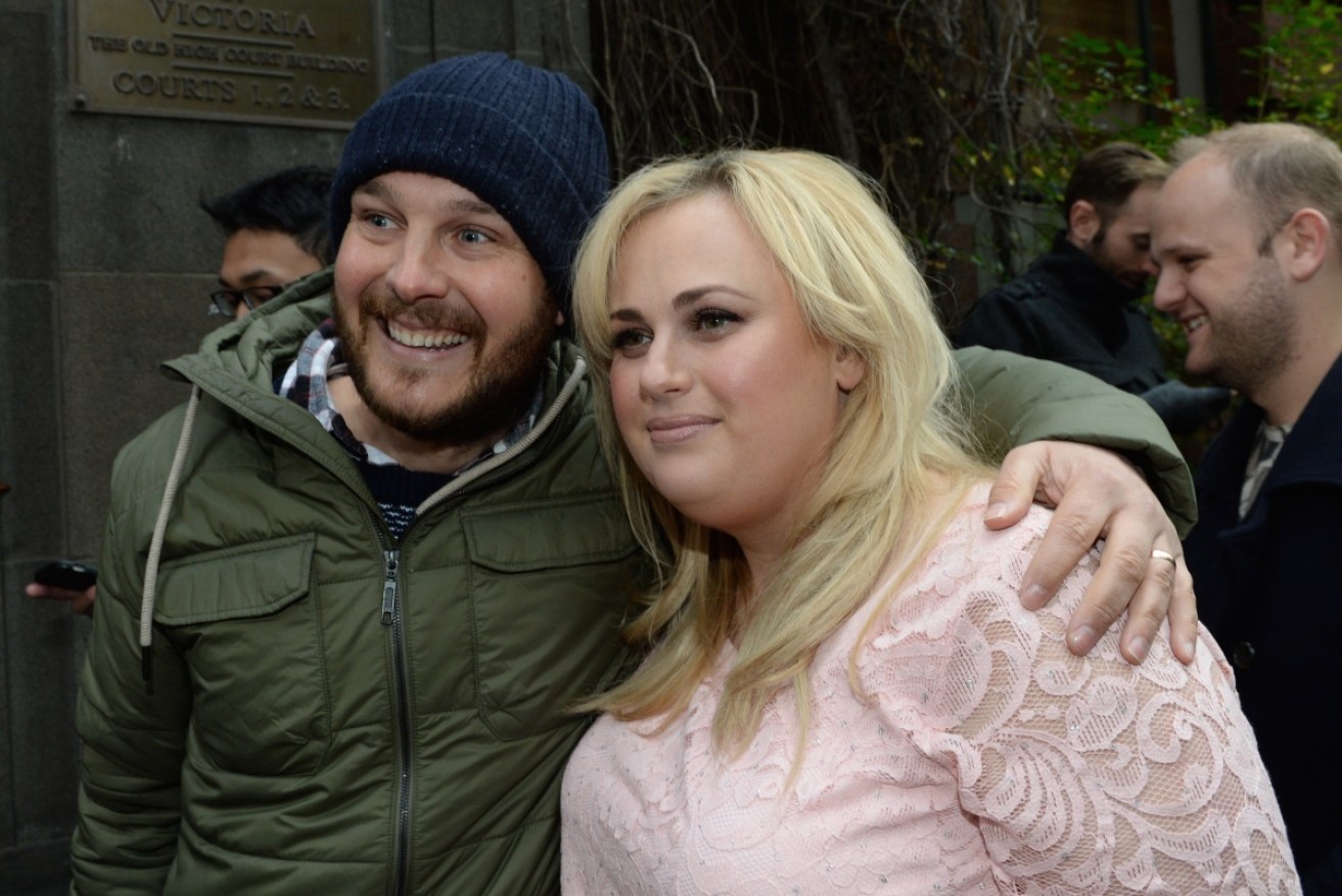 Rebel Wilson poses for photos with a fan outside court in Melbourne.