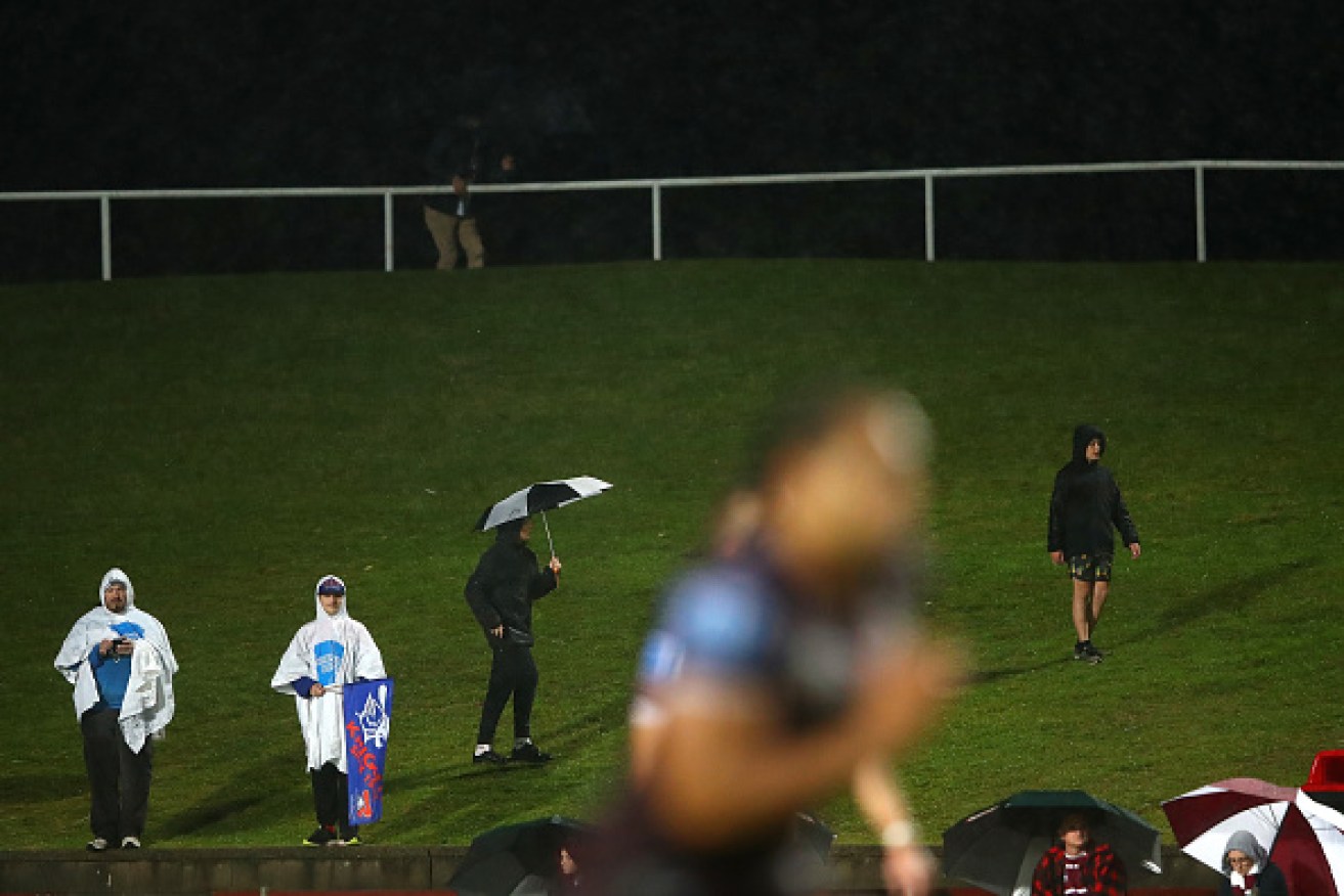 Fans brave the weather at an NRL match in Sydney on Friday.