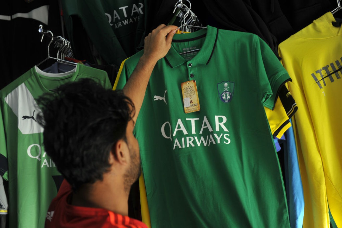 A man looks at a shirt of Saudi Arabia's Al-Ahli Football Club bearing a Qatar Airways' logo in the city of Jeddah on Tuesday