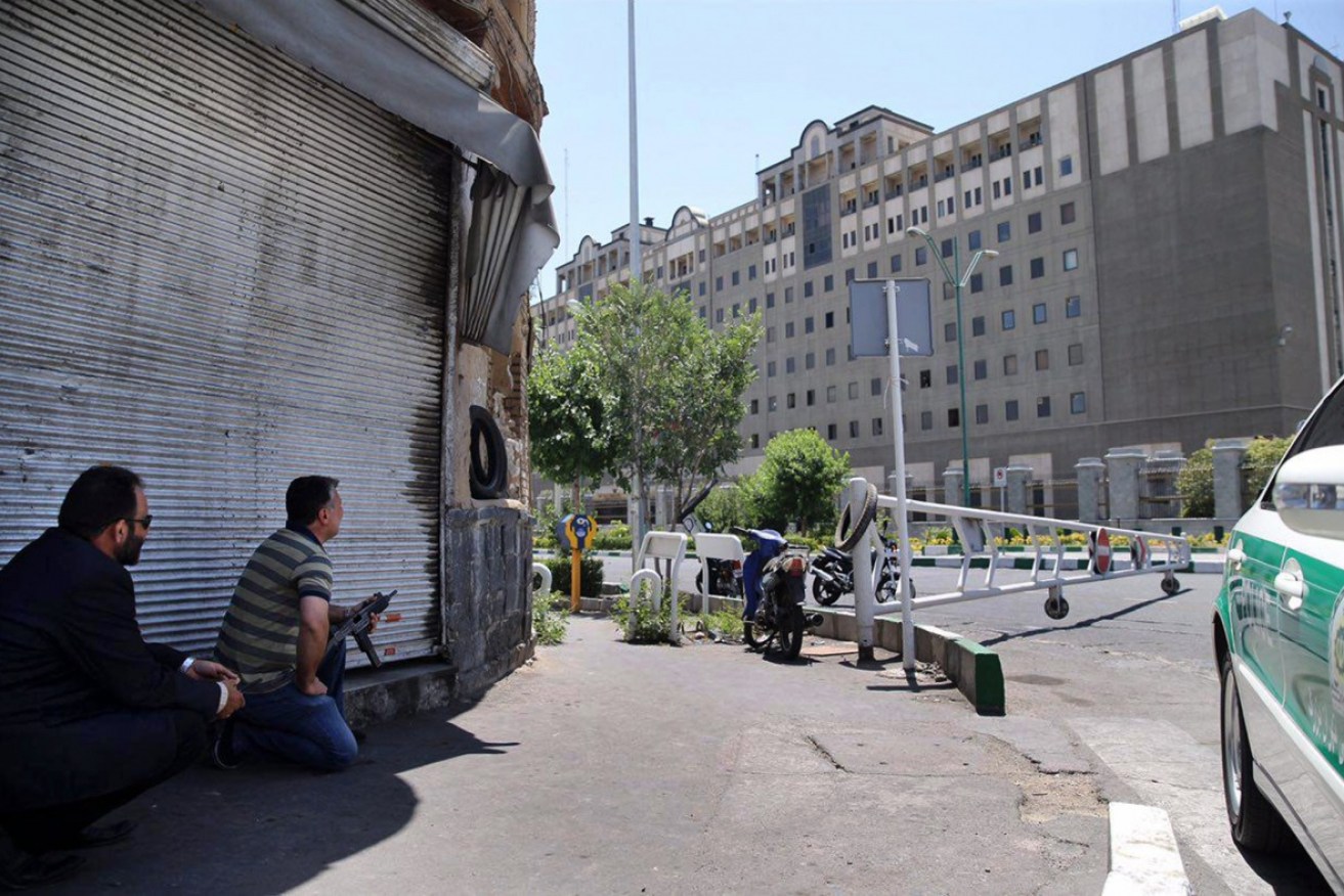 Security personnel take position in front of Iran's parliament building after an assault by several attackers in Tehran.