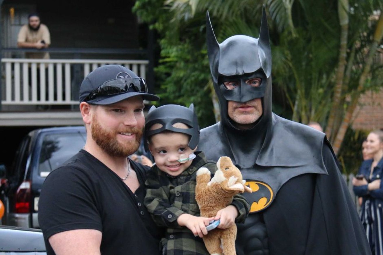 Jeff and Eli Vale pose for a photo with Batman, AKA Craig Blackburn.