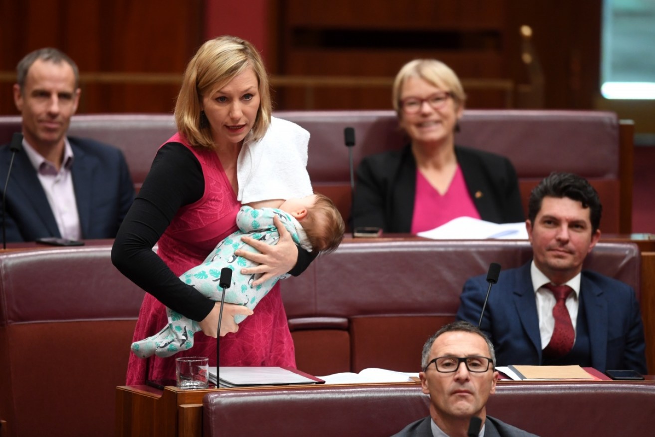 Larissa Waters breastfeeds her baby while moving a motion in federal parliament.