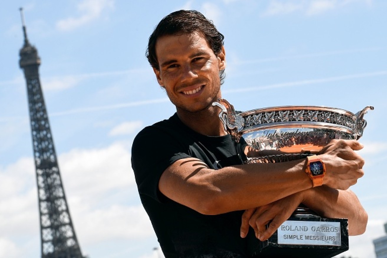 Spain's Rafael Nadal cradles the French Open trophy, a day after winning his 10th title at Roland Garros.