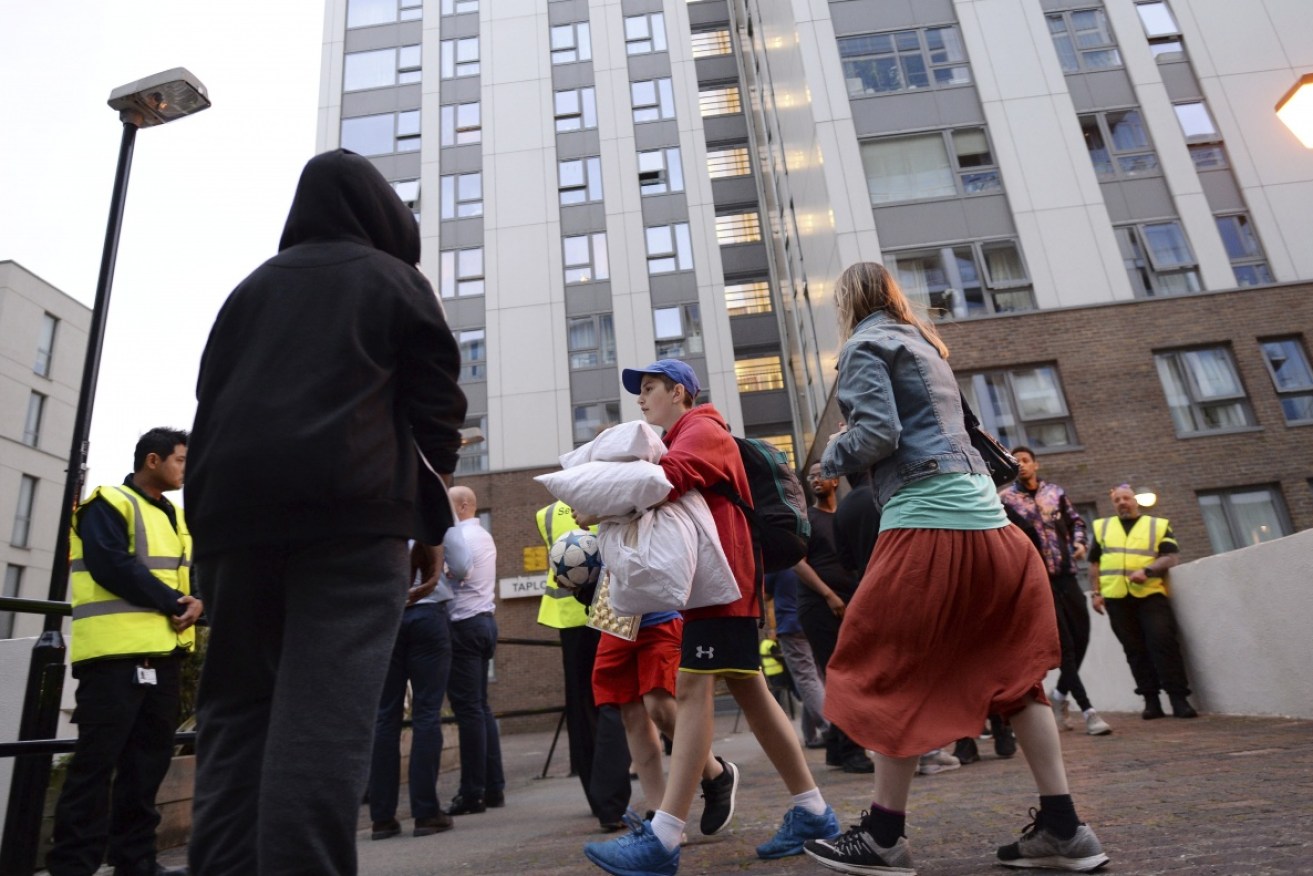 Residents leave a tower block on the Chalcots Estate in Camden on Friday night to allow 'urgent fire safety works' to take place. Photo: AAP