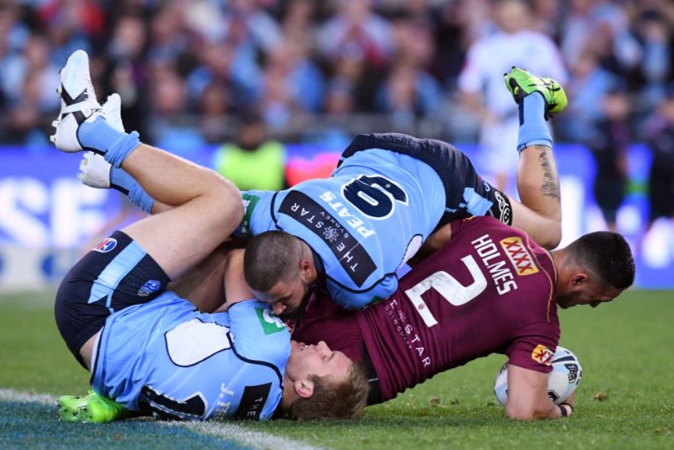 Valentine Holmes of the Maroons is tackled by Jake Trbojevic (left) Blues during State of Origin II's thriller.