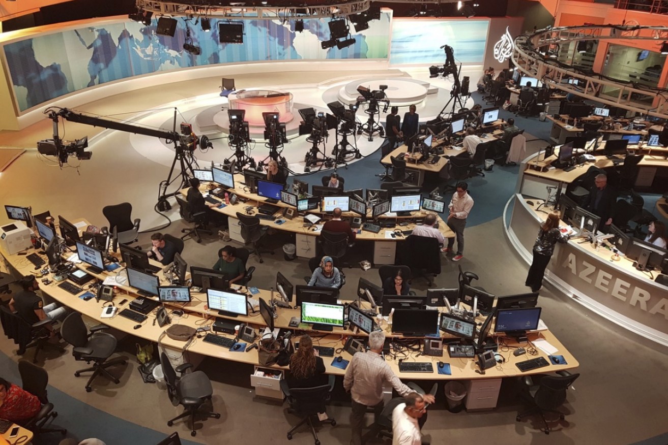 Al Jazeera staff work at their TV station in Doha, Qatar. 