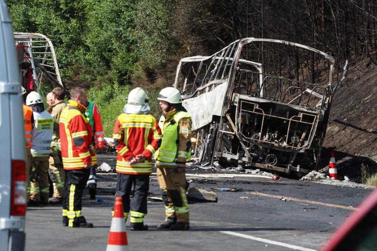 Fire fighters and emergency services next to a burned-out bus in Germany.
