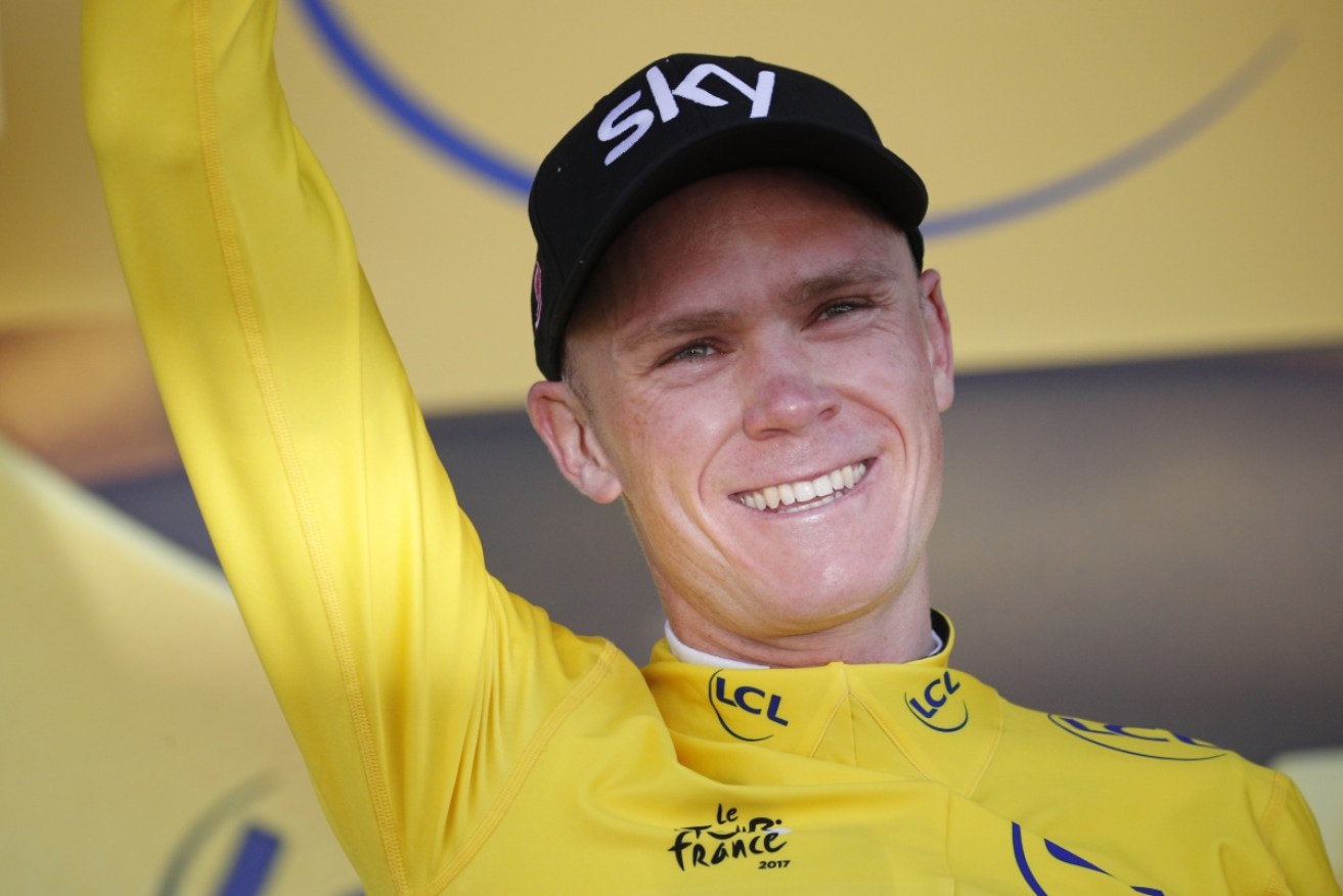 New overall leader, Britain's Chris Froome, celebrates on the podium with his yellow jersey after the fifth stage of the Tour de France.
