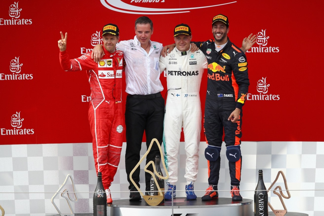 Sebastian Vettel, Valtteri Bottas and Australian driver Daniel Ricciardo celebrate on the podium.