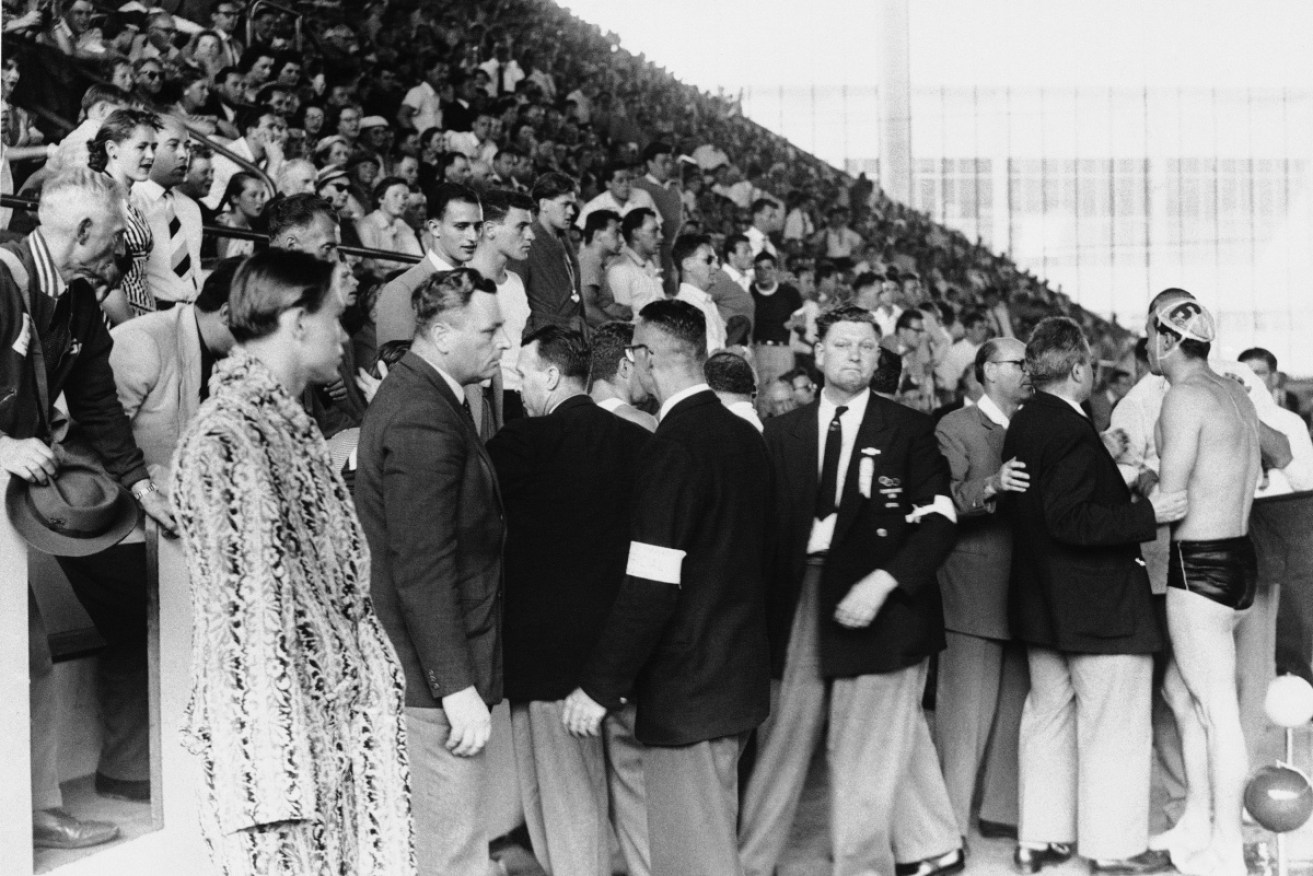 The crowd surrounds the Russian Water Polo team as the Hungary vs Russia match ends in chaos at Melbourne's 1956 Olympics.
