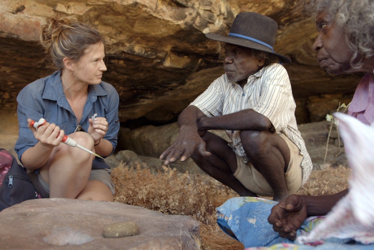 Elspeth Hayes, Mark Djandjomerr and traditional owner May Nango extract comparative samples to aid in their analysis of an ancient rock shelter in Kakadu National Park that could change our view of human history.