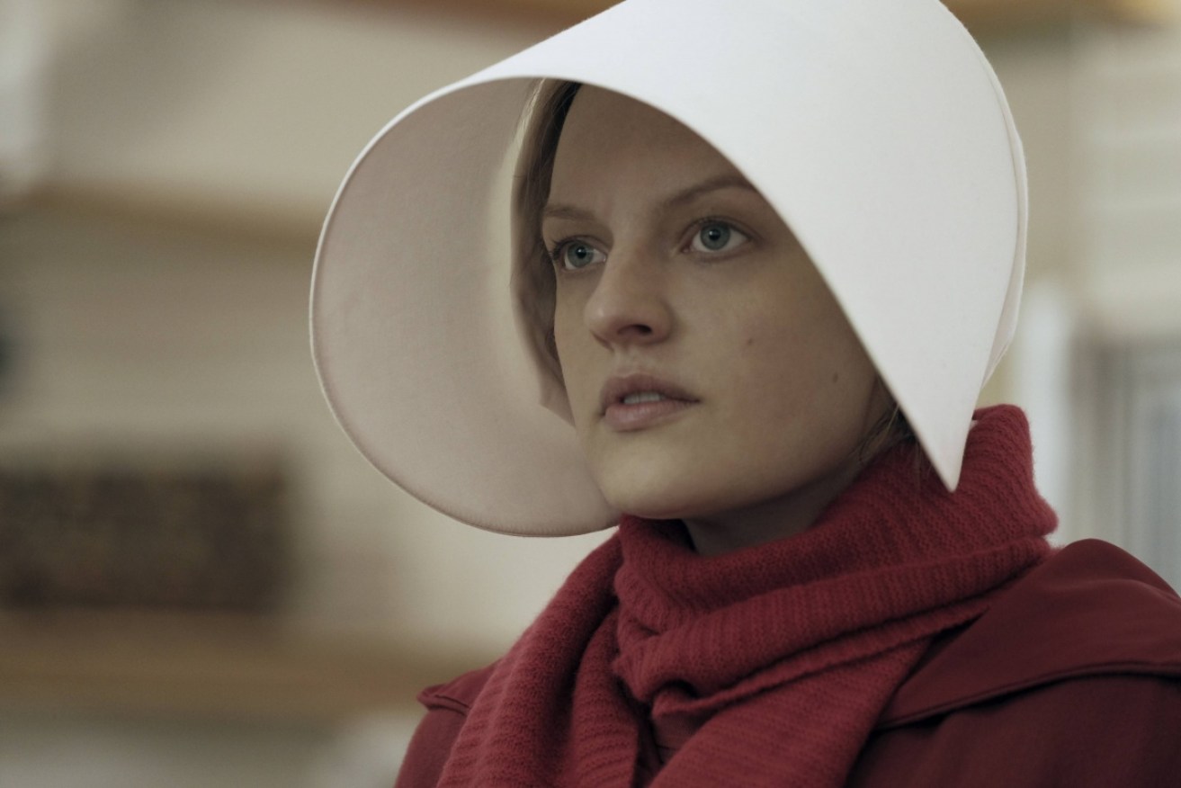 In <i>The Handmaid's Tale</i>, Elisabeth Moss plays a woman forced to bear children for infertile couples.