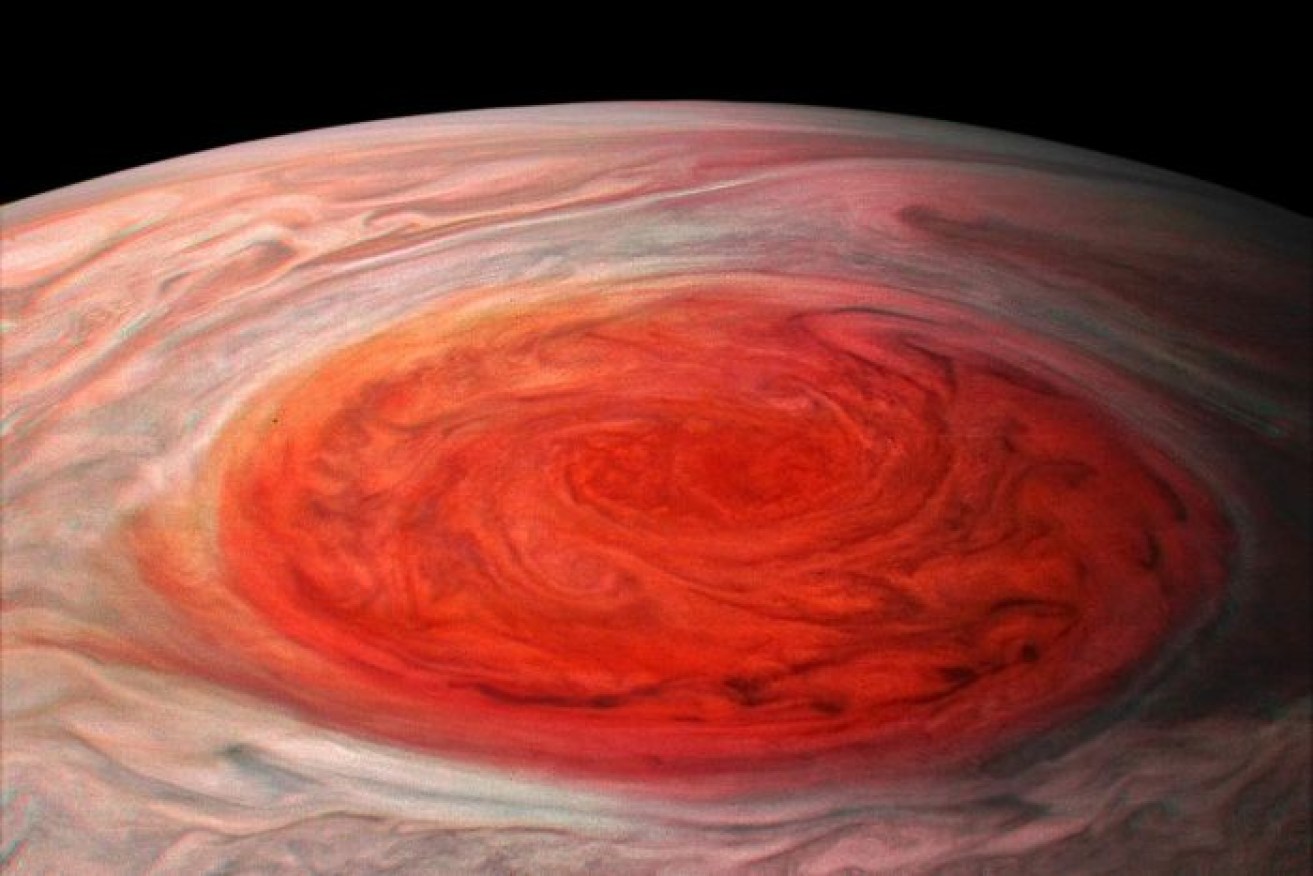 A close-up image shows Jupiter's Great Red Spot as Juno approaches the planet.