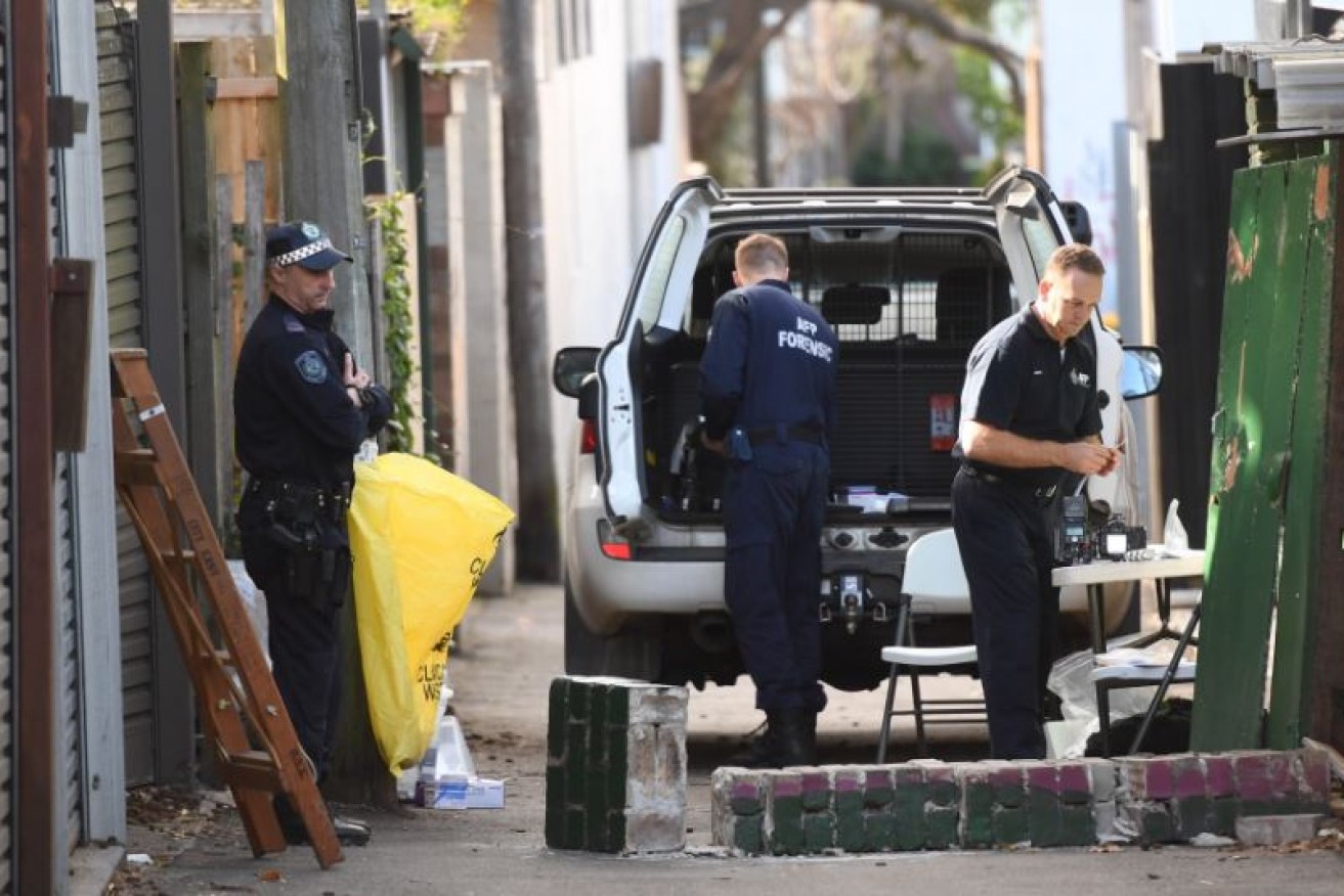 Police gather evidence at the rear of a raided Surry Hills property. Photo: AAP