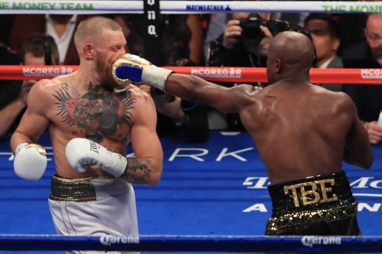 Floyd Mayweather lands a punch on Conor McGregor during their Las Vegas fight. 