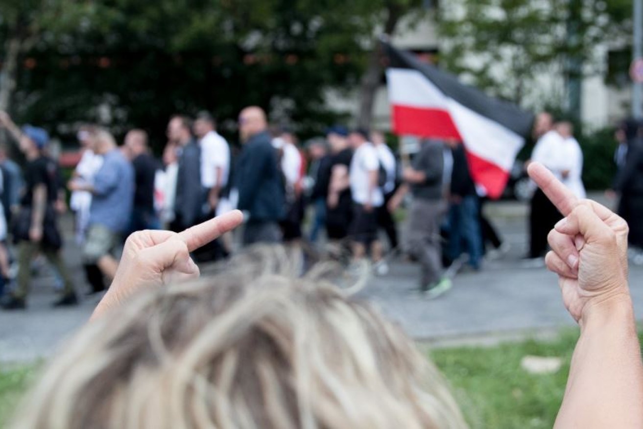 A protester tells neo-Nazis where to go in Berlin.